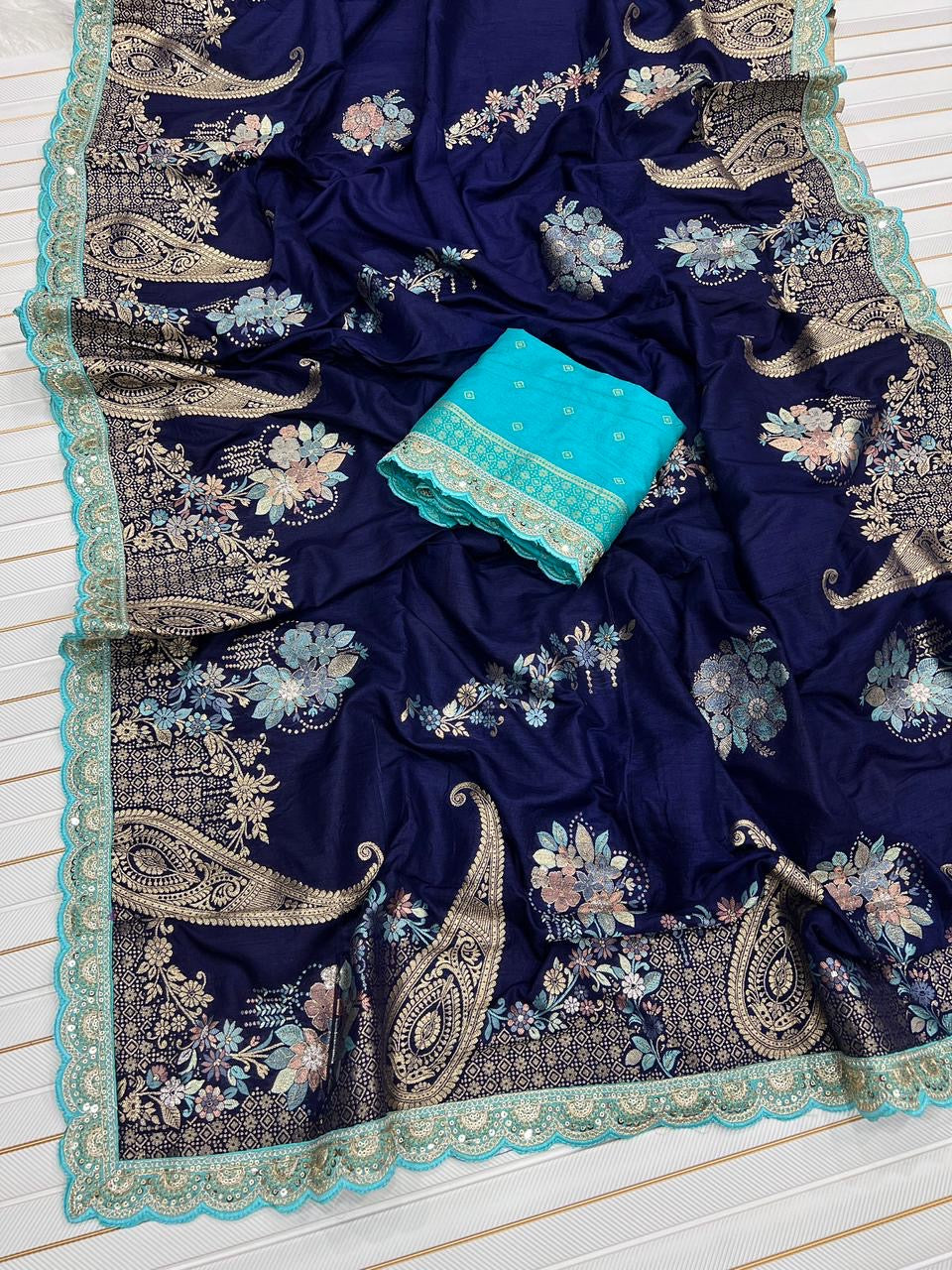 Navy blue saree with floral and paisley patterns on a white background