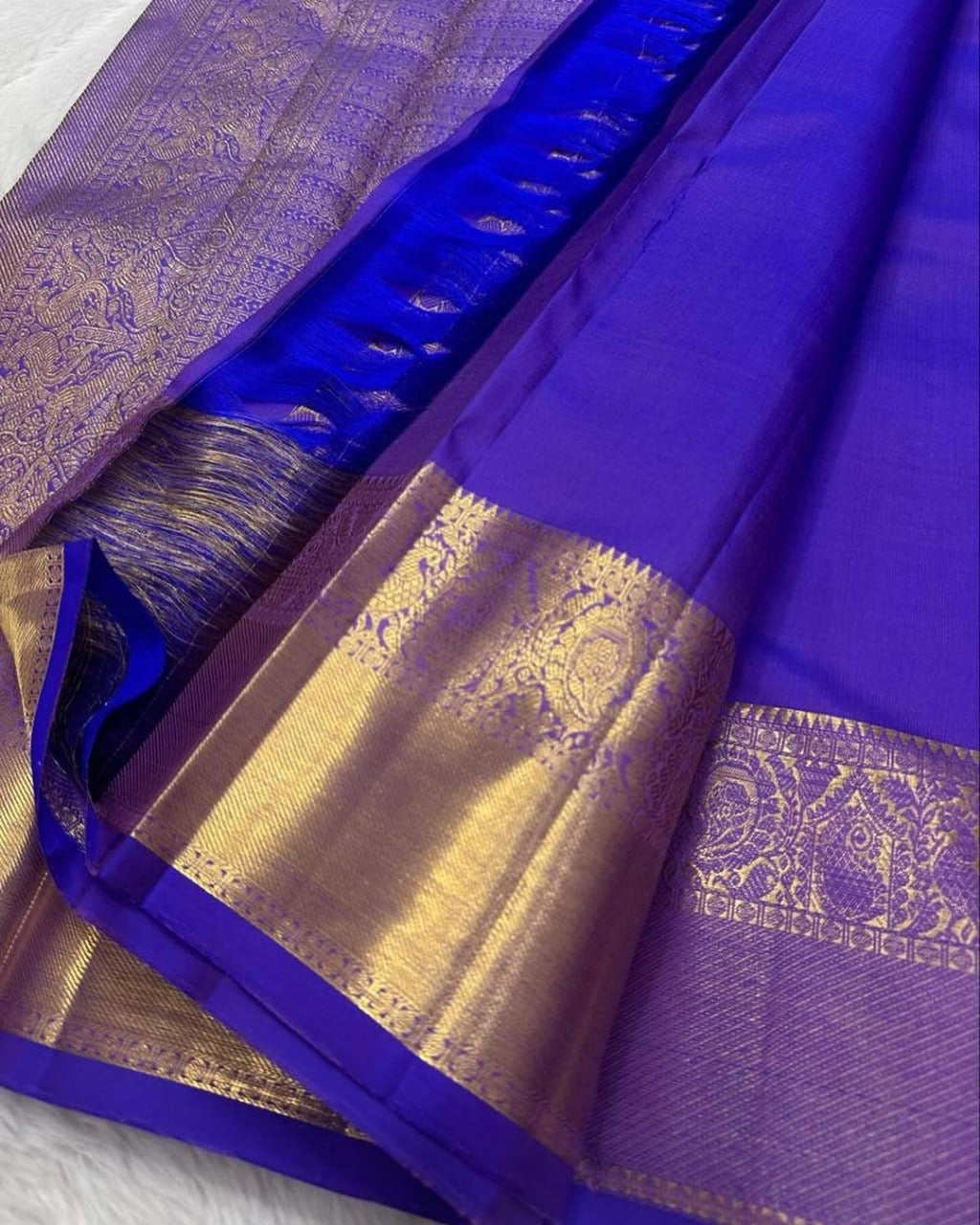 Purple saree with gold border on a white background