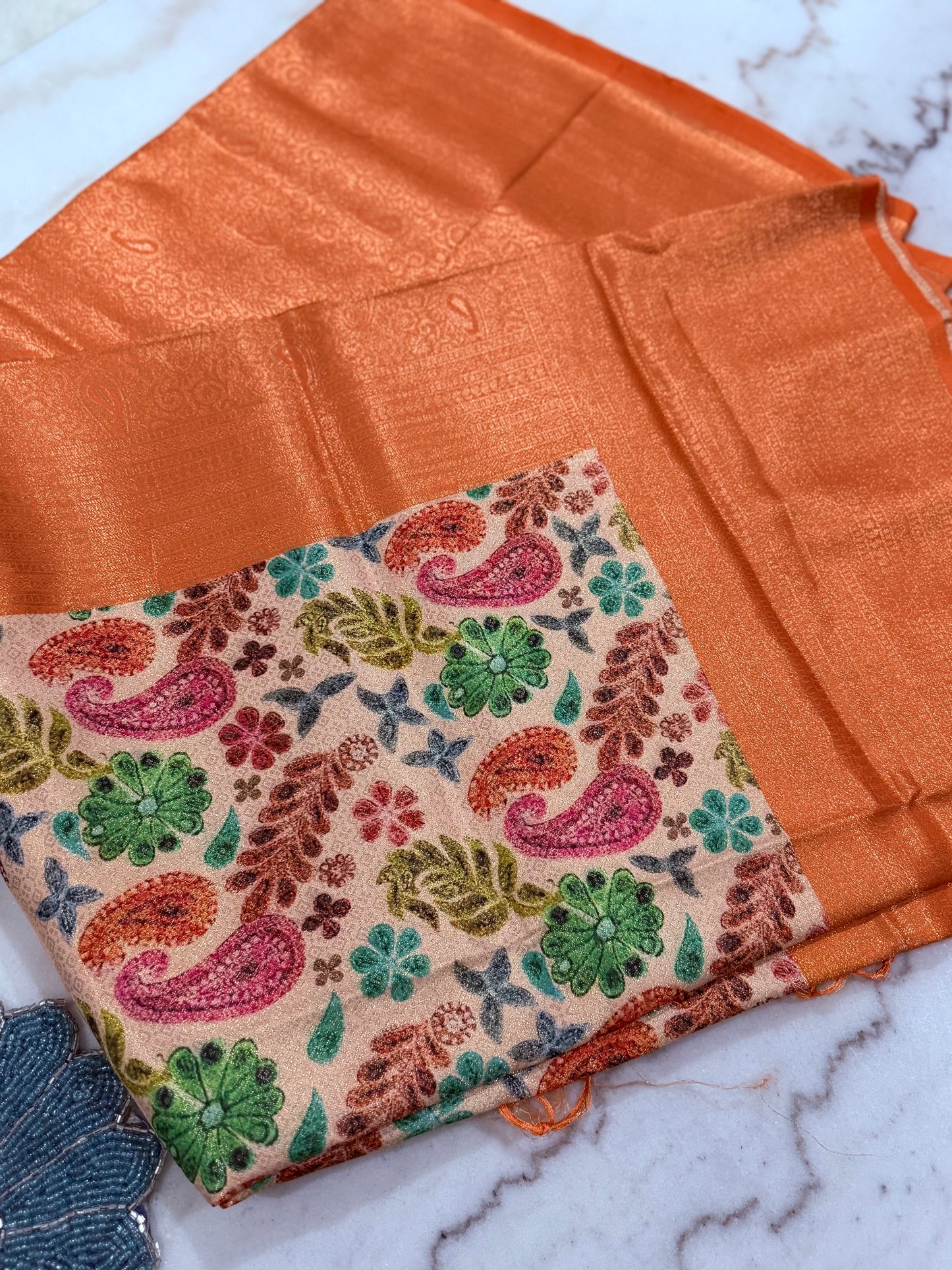 Fabric with floral and paisley pattern on a marbled surface