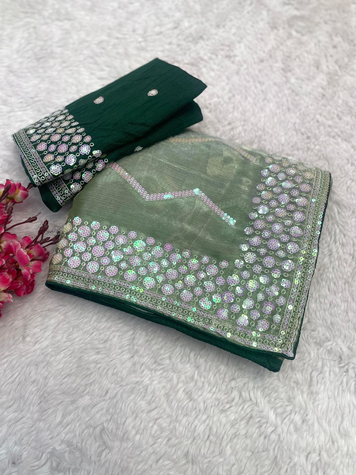 Green embroidered fabric with a matching clutch on a light gray background