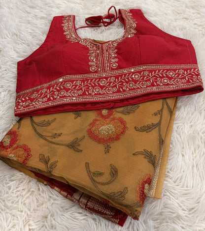 Red embroidered blouse and beige saree with floral patterns on a white surface