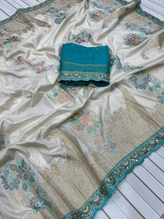 White saree with floral patterns and a blue border on a white wooden surface
