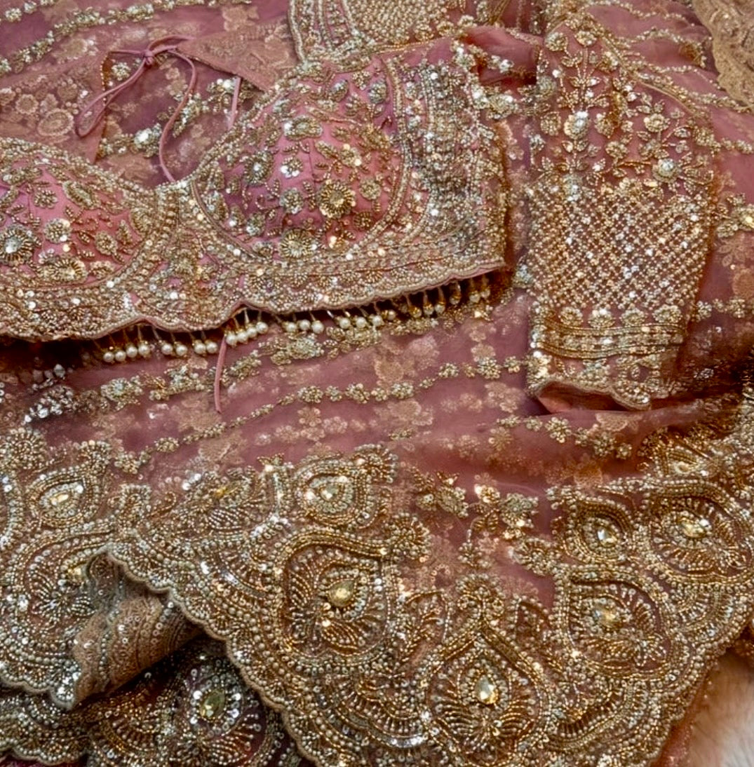 Close-up of pink fabric with intricate gold embroidery
