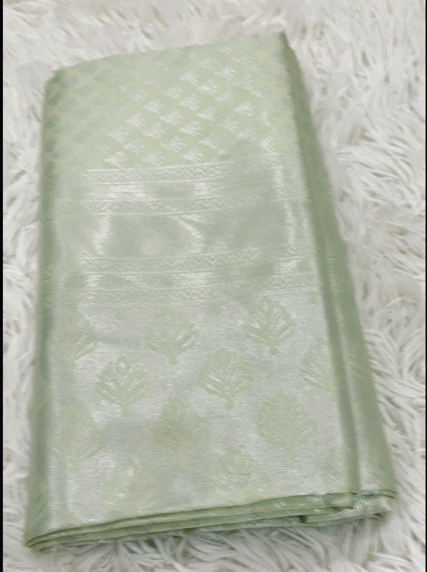 Folded light green fabric on a textured white surface