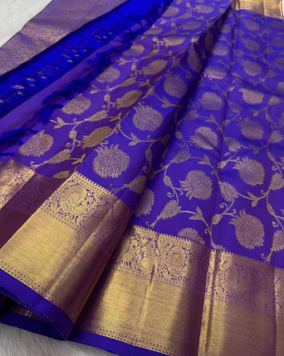 Blue saree with gold and white floral patterns on a plain background