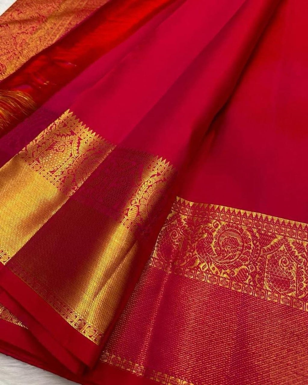 Red saree with gold border and patterns