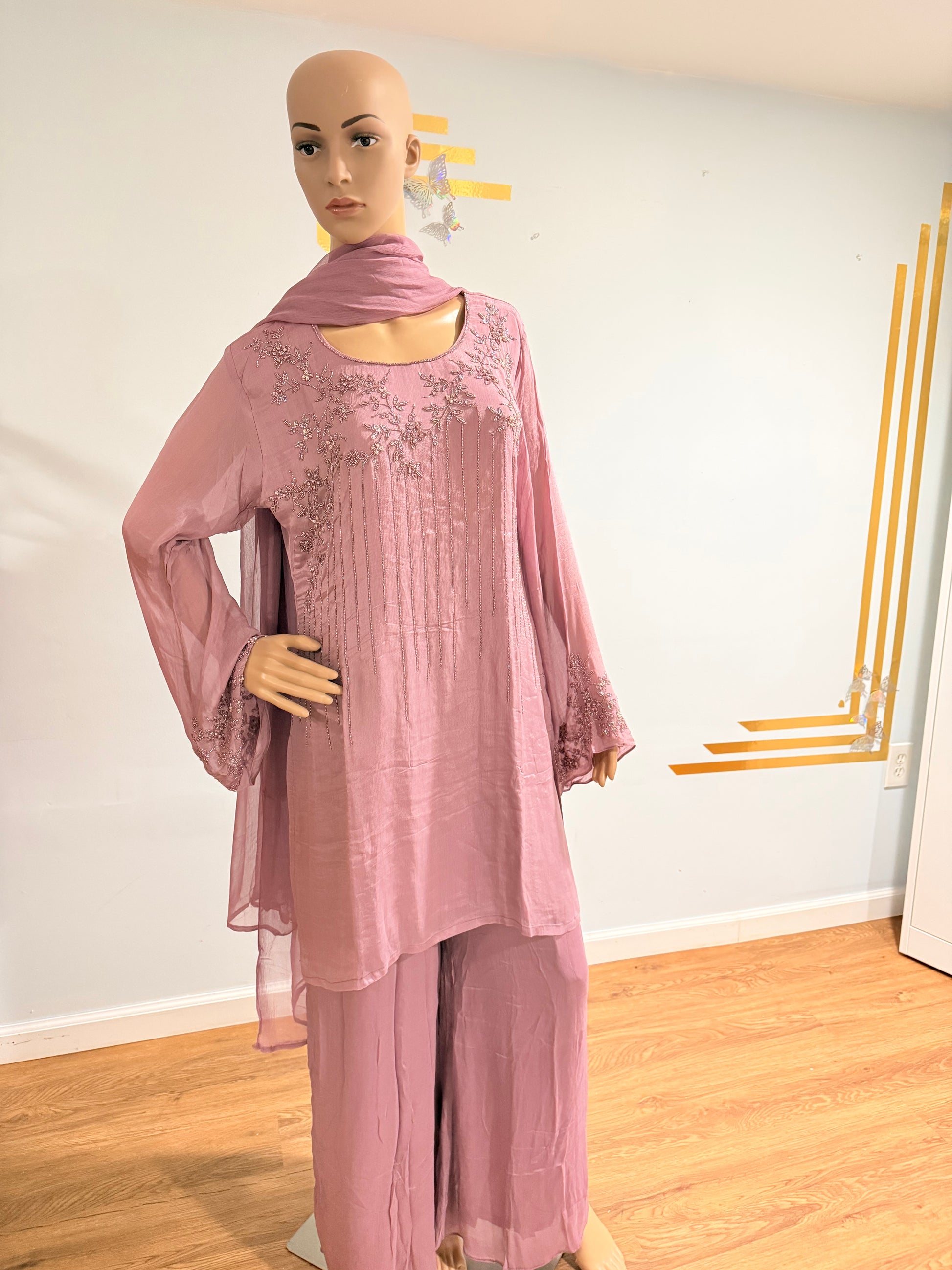 Mannequin wearing a pink dress with long sleeves on a white background