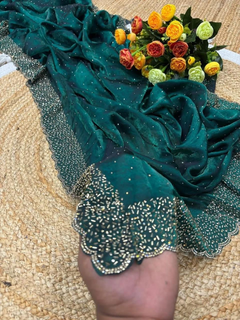 Teal fabric with decorative trim and a bouquet of flowers on a textured surface