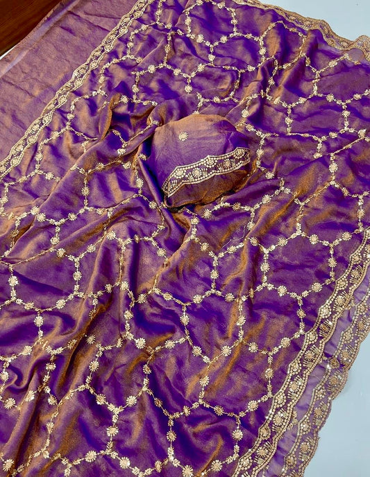 Purple fabric with gold embroidery on a light blue background