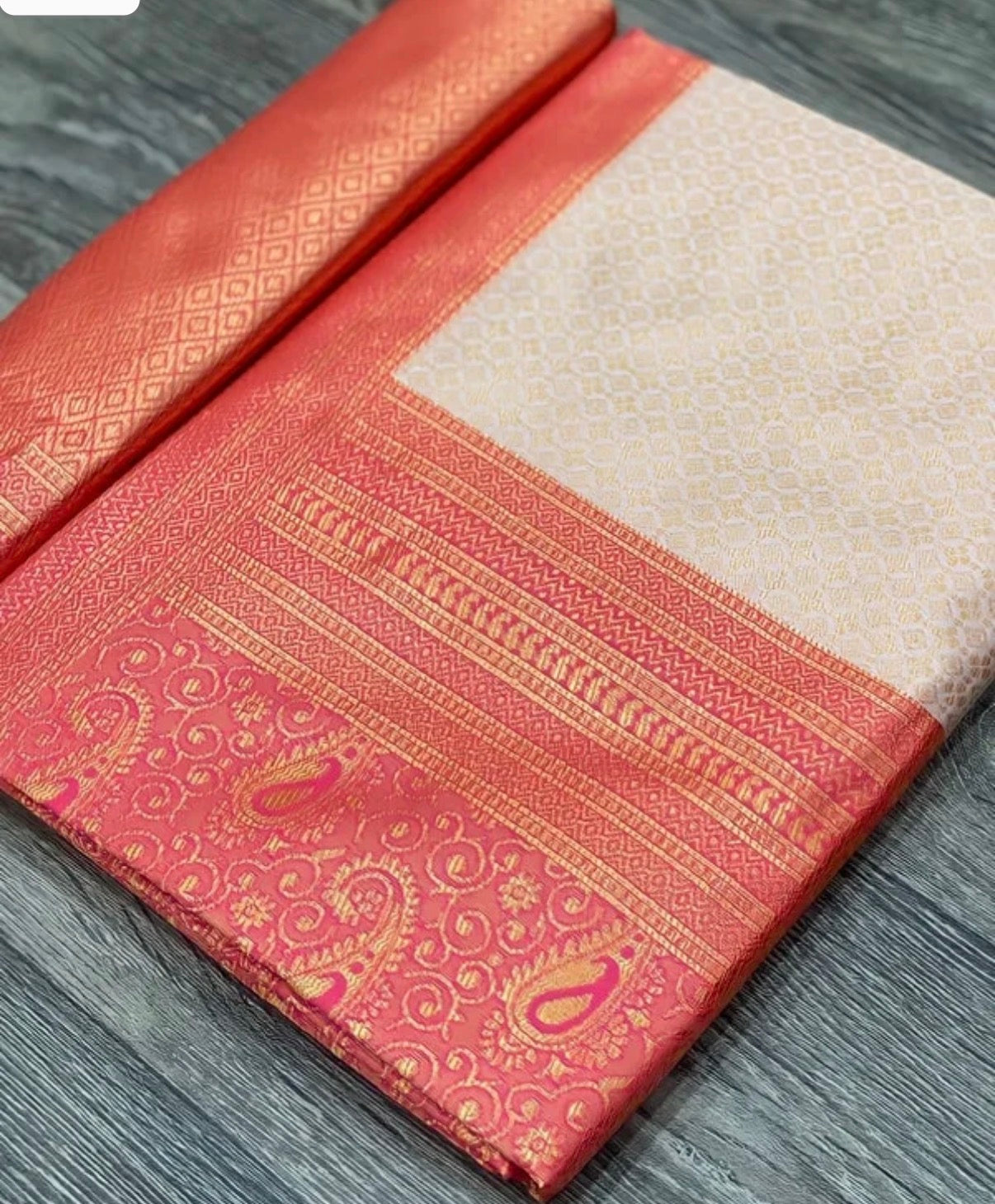 Red and white saree with intricate patterns on a gray surface