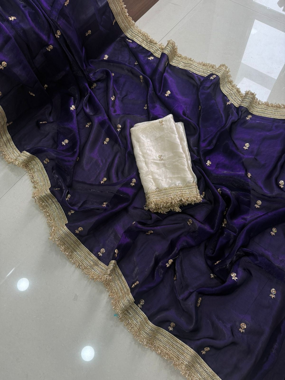Purple fabric with gold embroidery on a white surface