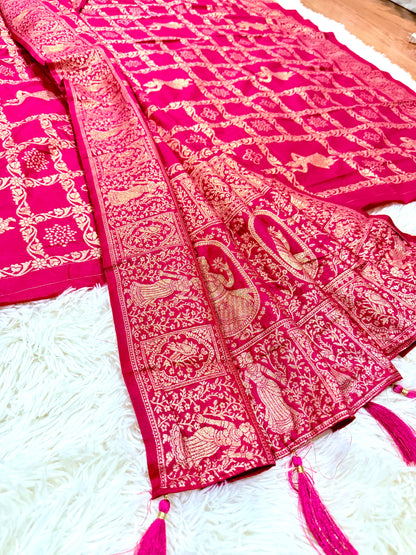 Pink saree with intricate patterns on a white surface