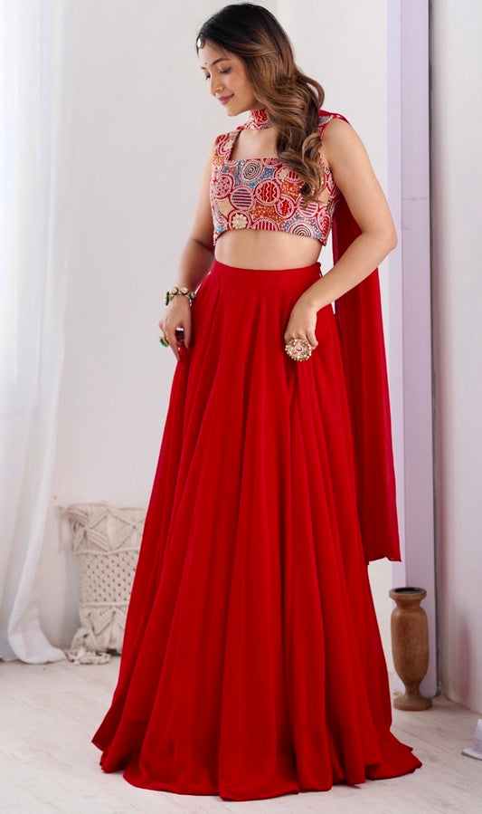 Woman wearing a red outfit with a patterned top against a white curtain background