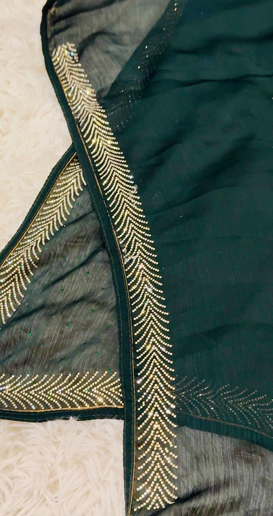 Dark green fabric with gold embroidery on a textured surface