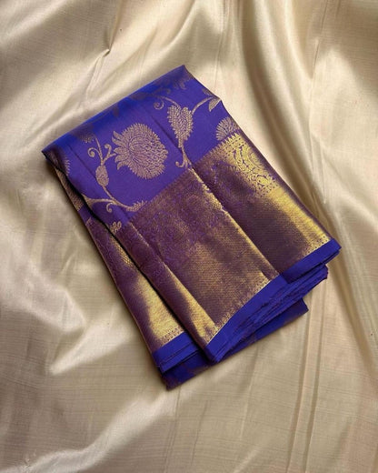 Blue and gold saree with floral patterns on a beige fabric background