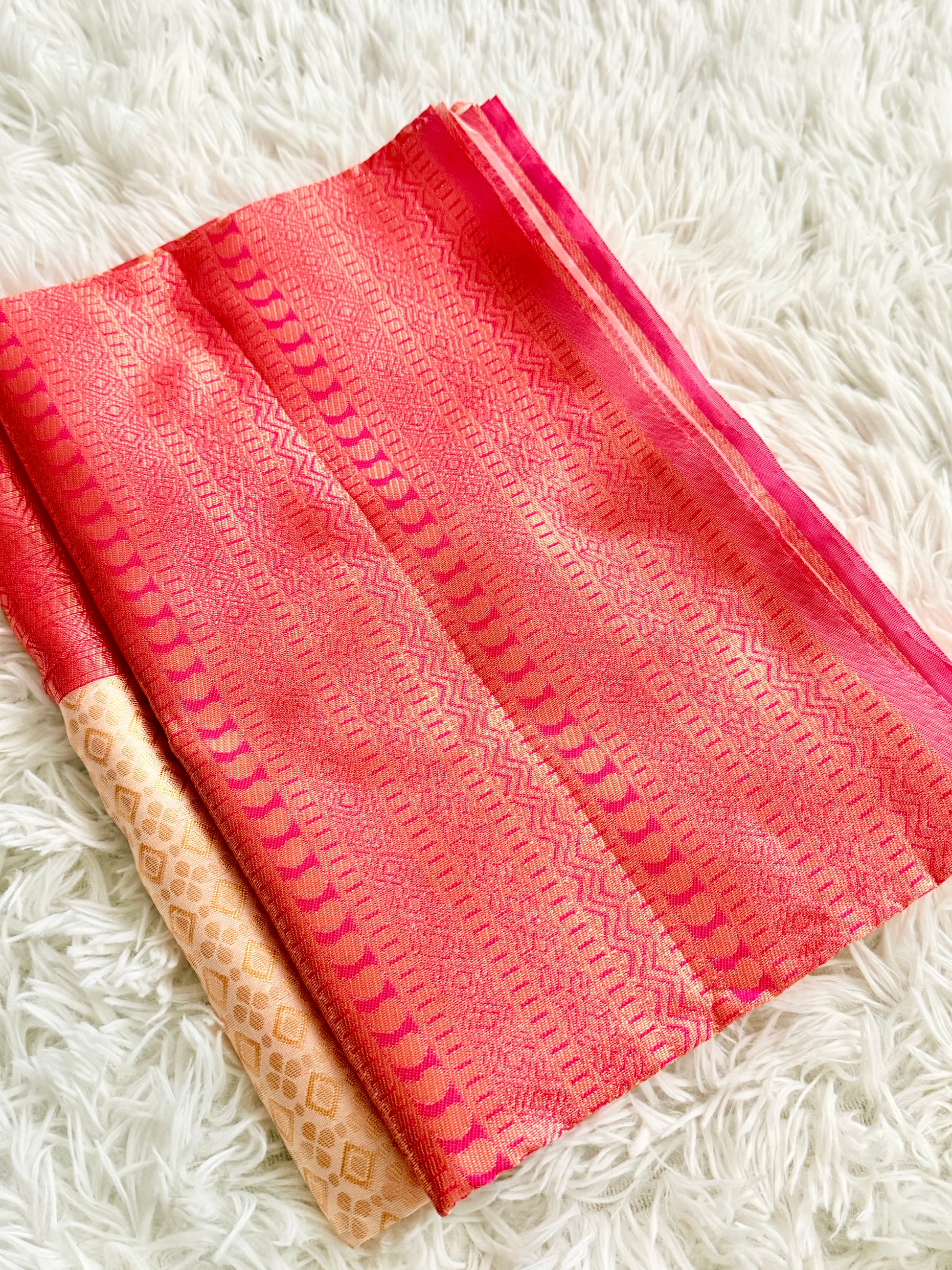 Pink fabric with a subtle pattern on a white fluffy surface