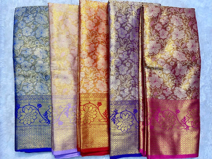 Five floral patterned scarves in different colors on a light blue background