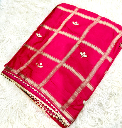 Red saree with gold patterns on a white textured background