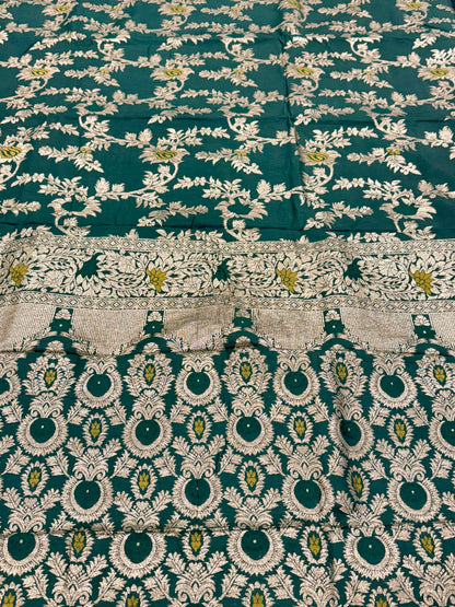 Green fabric with intricate white and gold embroidery