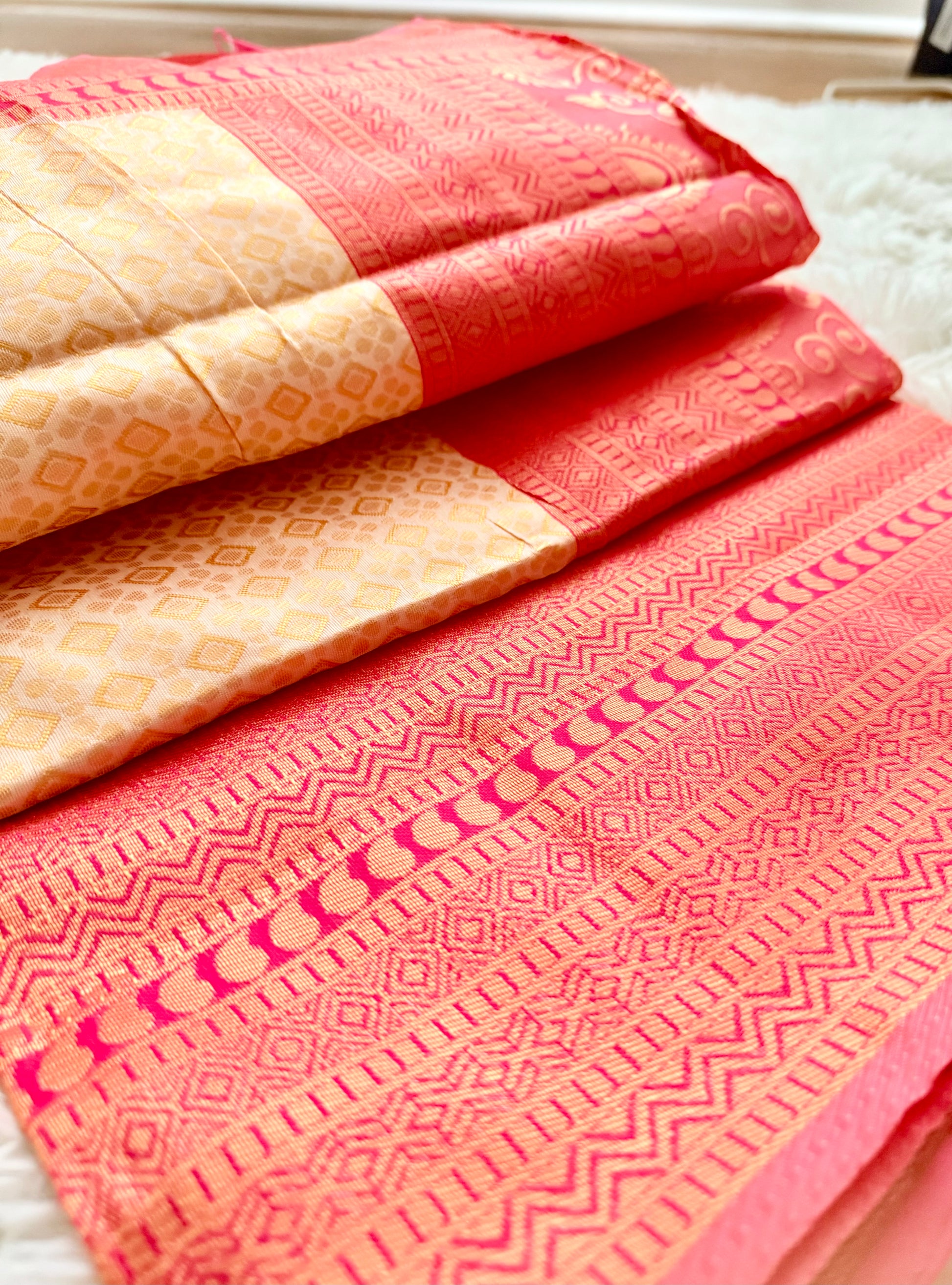 Folded fabric with red and beige patterns on a white surface