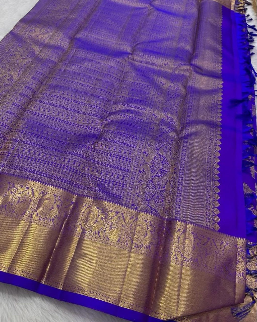 Purple saree with gold border on a white background