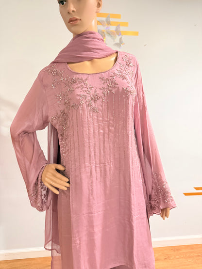 Mannequin wearing a pink dress with floral embellishments on a plain background