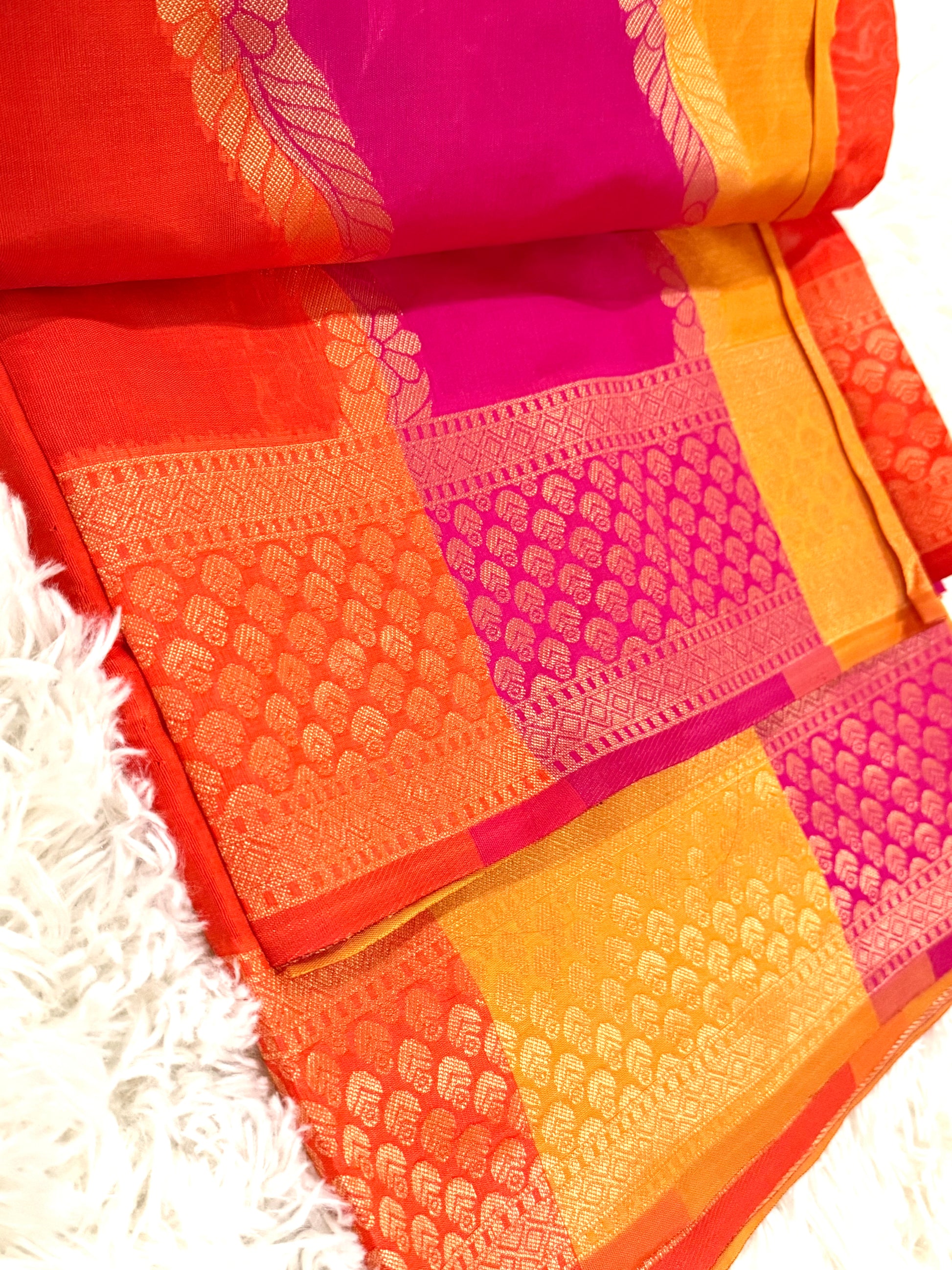 Colorful saree with pink and orange patterns on a white background