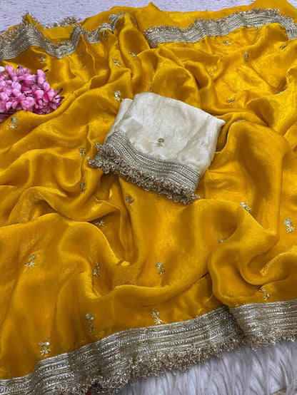 Yellow saree with silver border and pink flowers on a light gray background