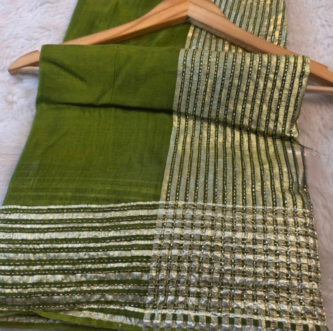 Green fabric with gold and silver pattern on a wooden hanger
