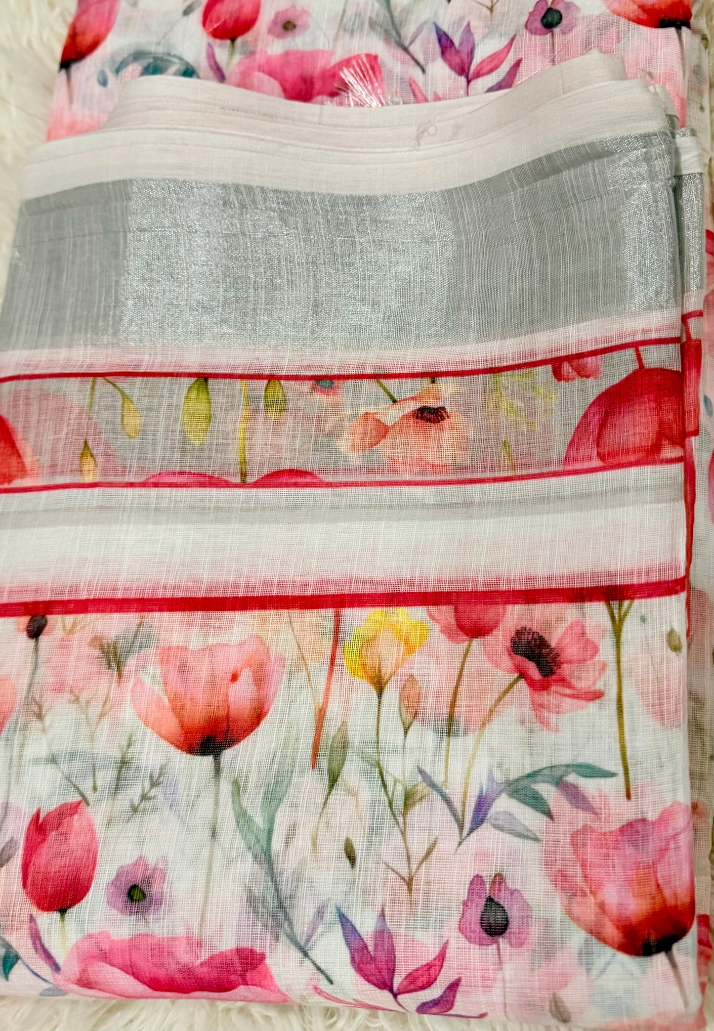 Floral patterned fabric with pink flowers and green leaves on a white background