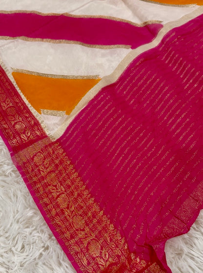 Close-up of a pink saree with gold border on a white background