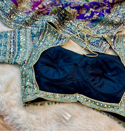 Decorative blouse with intricate patterns and embellishments on a textured surface