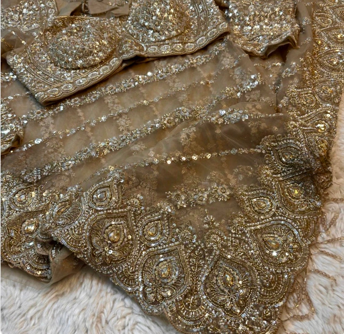 Close-up of embroidered fabric with intricate patterns and embellishments.