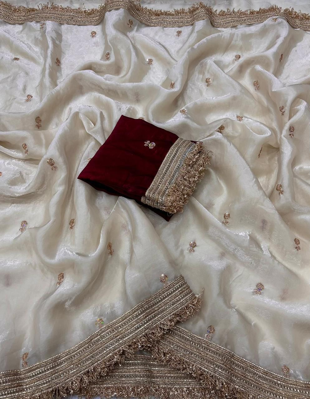 White fabric with gold embroidery and a red and gold decorative item on top