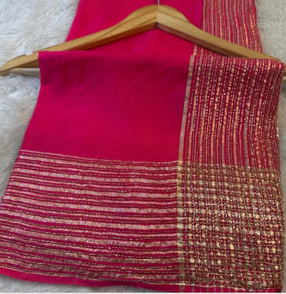 Red saree with gold border on a wooden hanger