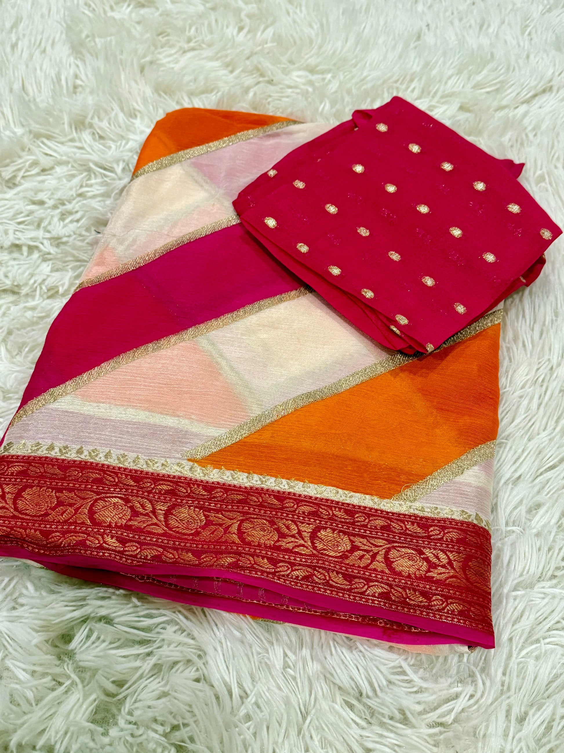 Colorful saree with a pink blouse on a white textured surface