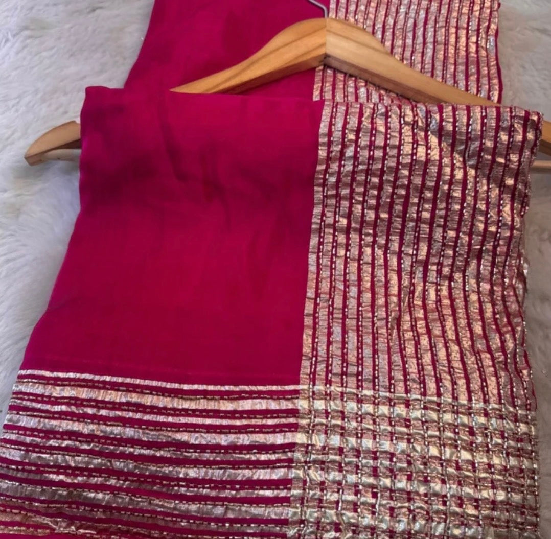 Red and gold patterned fabric on a hanger against a white background