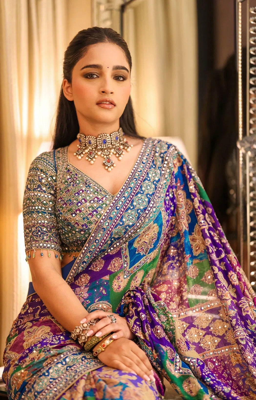 Woman in a traditional saree with intricate patterns and jewelry.