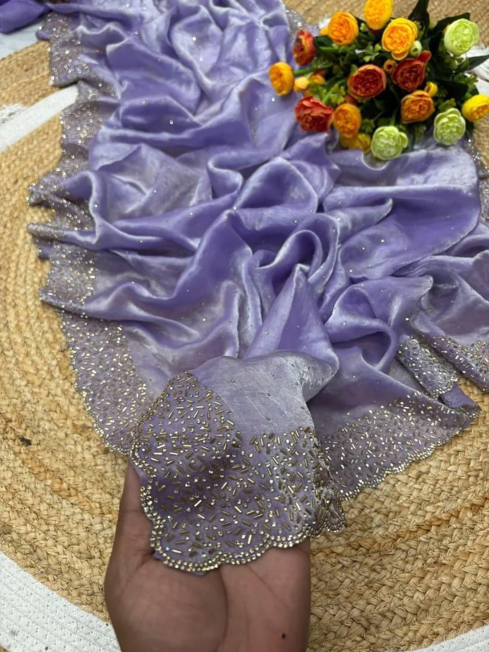 Decorative purple and silver fabric with floral arrangement on a textured surface