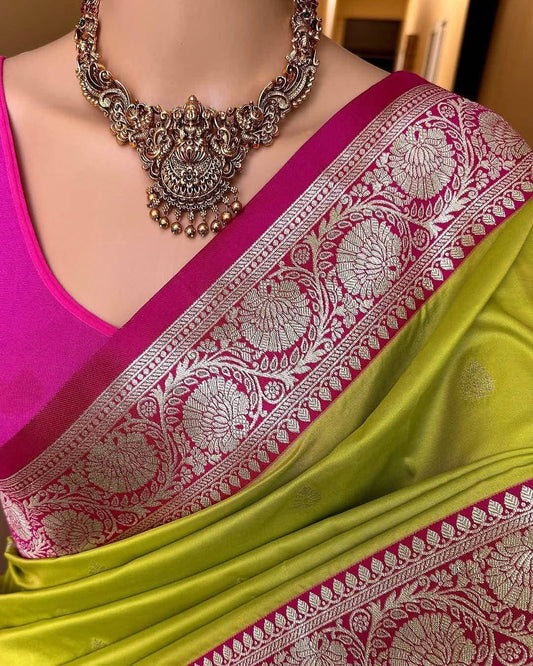 Green saree with pink border and silver jewelry on a mannequin