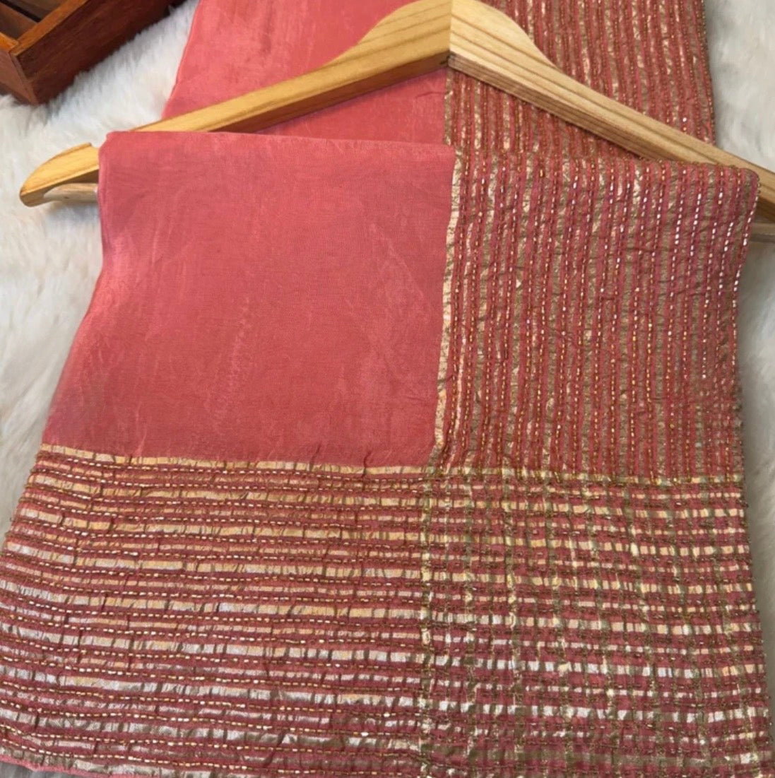 Red fabric with a textured pattern on a wooden hanger