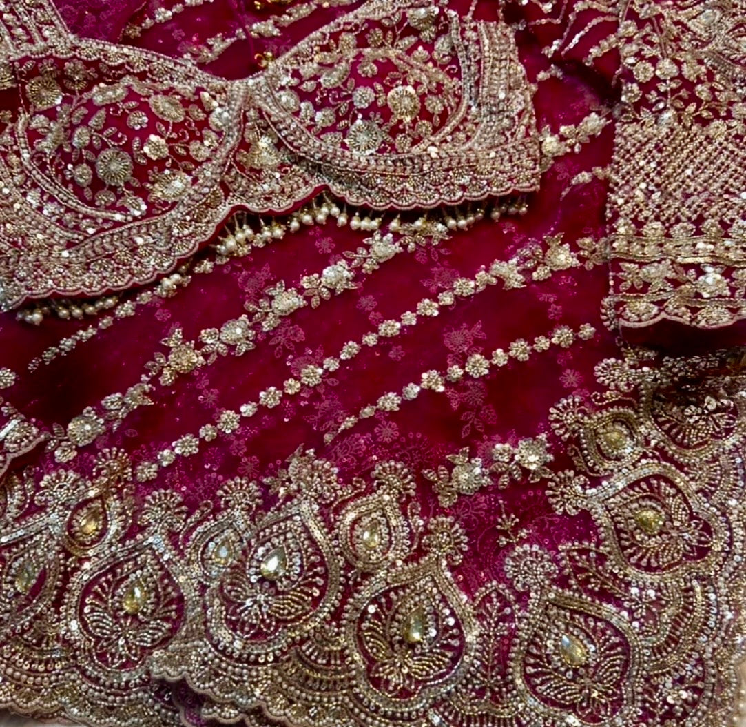 Close-up of a maroon fabric with intricate gold embroidery