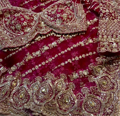 Close-up of a maroon fabric with intricate gold embroidery