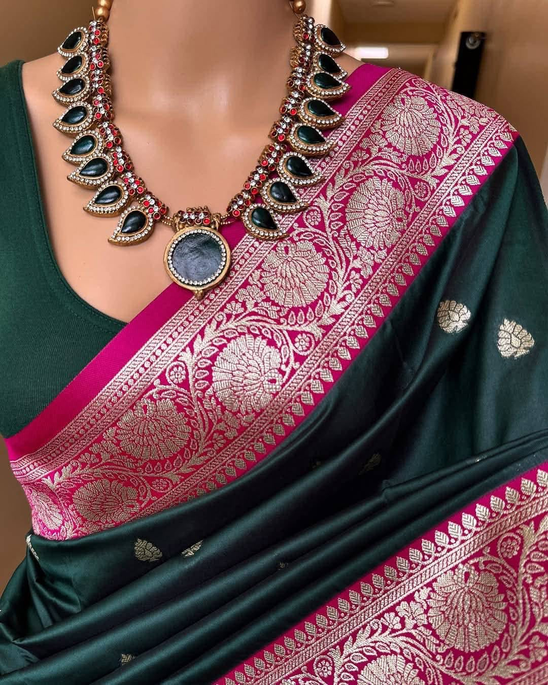 Green saree with pink border and necklace on a mannequin