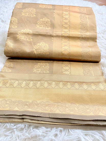 Beige saree with gold patterns on a white surface