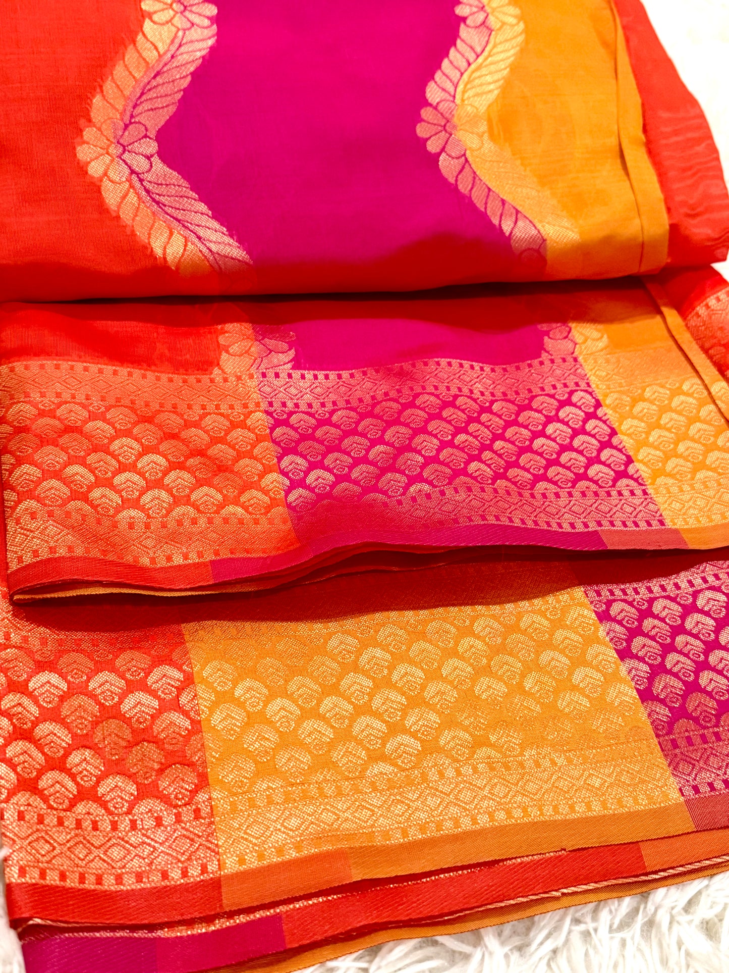 Colorful saree with pink and orange patterns on a white background