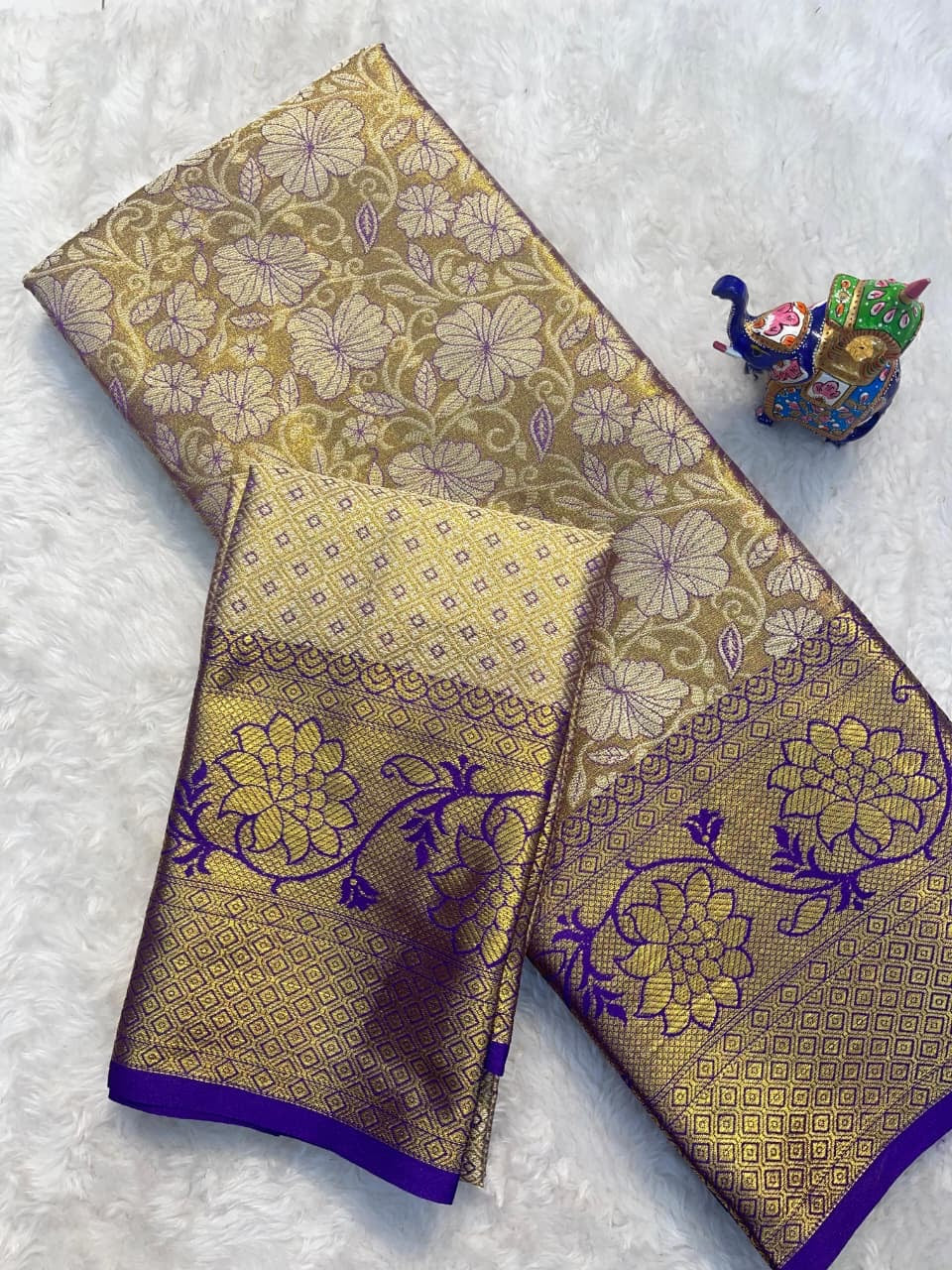 Two pieces of gold and purple patterned fabric on a white background