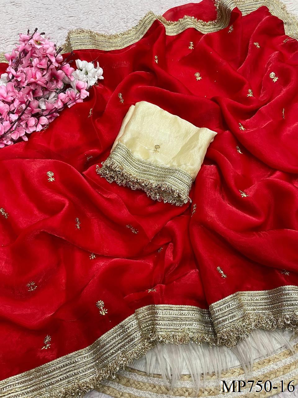 Red saree with gold border and white blouse, accompanied by pink flowers.