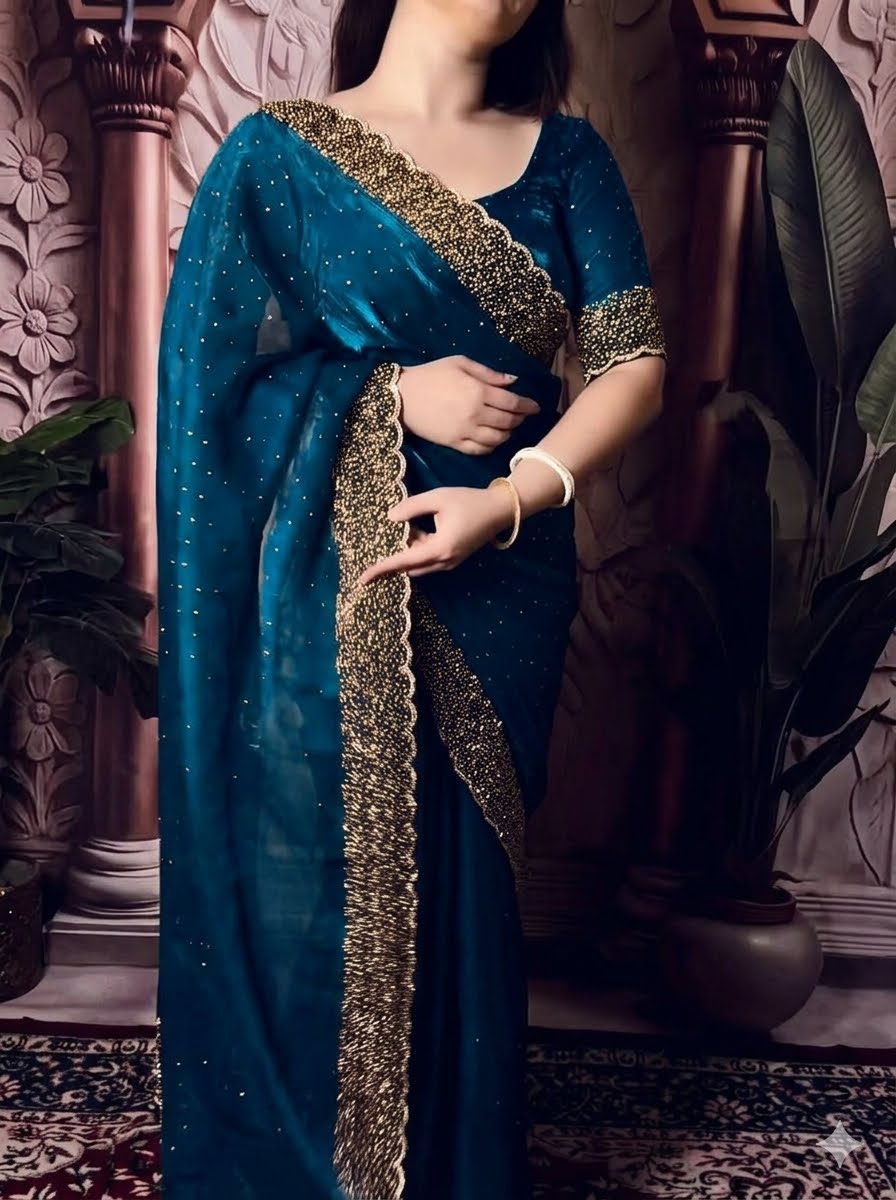 Woman wearing a blue saree with gold border indoors