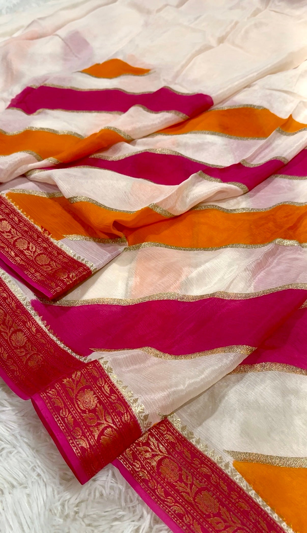 Colorful saree with pink and orange stripes on a white background